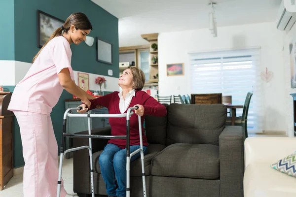Selbstbewusste Krankenschwester Hilft Gehbehinderter Seniorin Hause Mit Rollator Gehen — Stockfoto