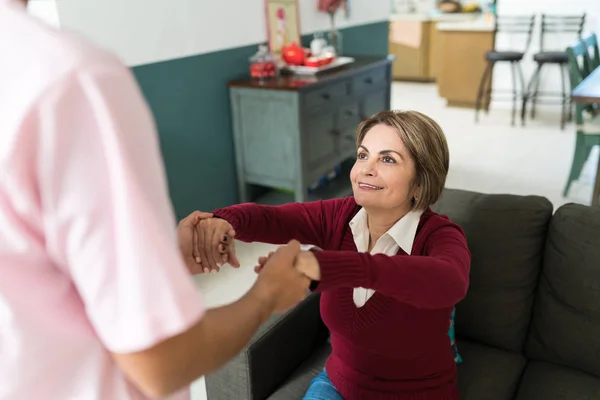 Nurse Helping Smiling Elderly Woman Sit Sofa Home — Stock Photo, Image