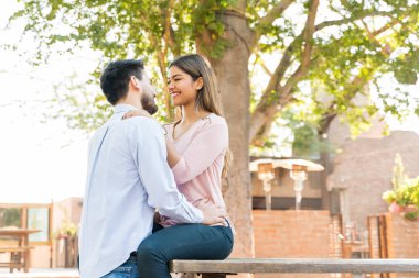 Happy Hispanic boyfriend and girlfriend embracing during date