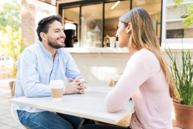 Kaldırımdaki kafede sevgilisi olan mutlu İspanyol bir adam.