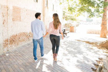 Yaya yolunda yürürken el ele tutuşan sevgili görüntüsü