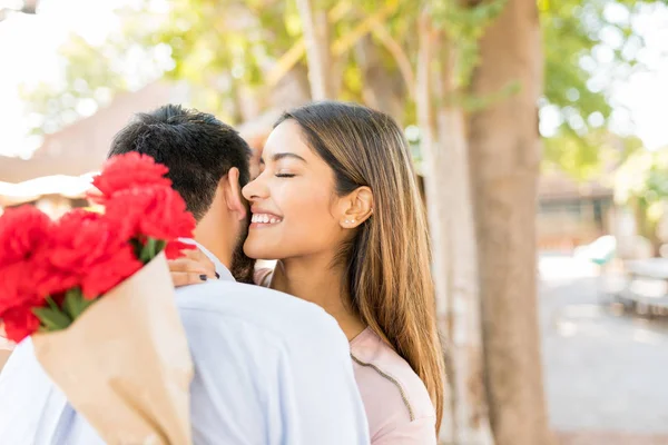 Sorrindo Atraente Jovem Segurando Flores Enquanto Abraçando Namorado — Fotografia de Stock