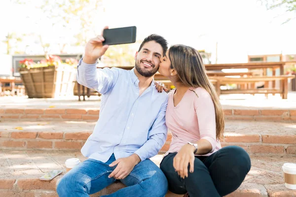 Feliz Hispânico Homem Tomando Selfie Enquanto Namorada Beijá Bochecha Café — Fotografia de Stock