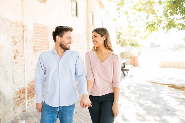 Happy Hispanic Lovers Holding Hands While Walking Footpath Sunny Day — стокове фото