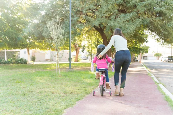 Rear View Mother Guiding Daughter Riding Bicycle Sidewalk Park — Stok Foto