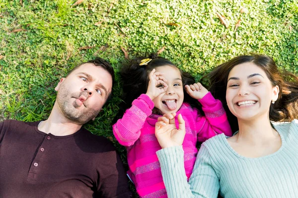 Alegre Familia Haciendo Caras Mientras Acuesta Hierba Parque — Foto de Stock