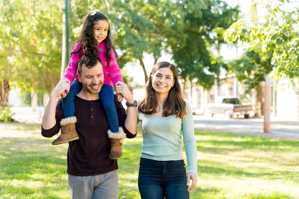 Smiling Latin Woman Walking Man Carrying Daughter Shoulders Park — Stok Foto