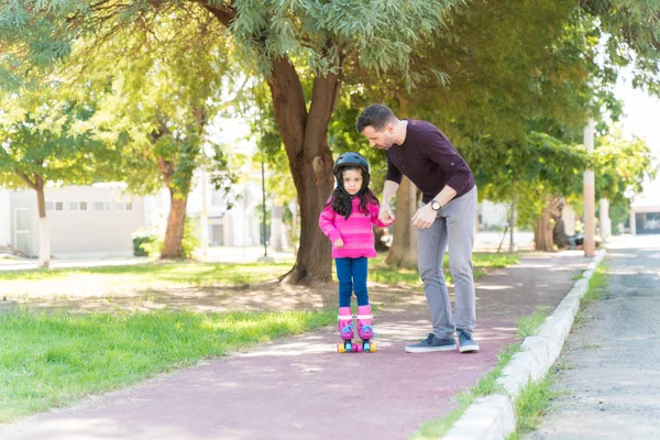 Father Guiding Daughter While Skating Sidewalk Park — Stock Photo, Image