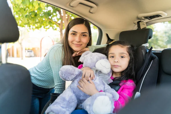 在车里抱着泰迪熊的女儿微笑美丽的年轻女子的肖像 — 图库照片