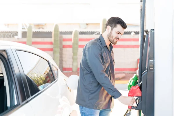 在加油站持有燃油泵的有信心的男性工作人员 — 图库照片