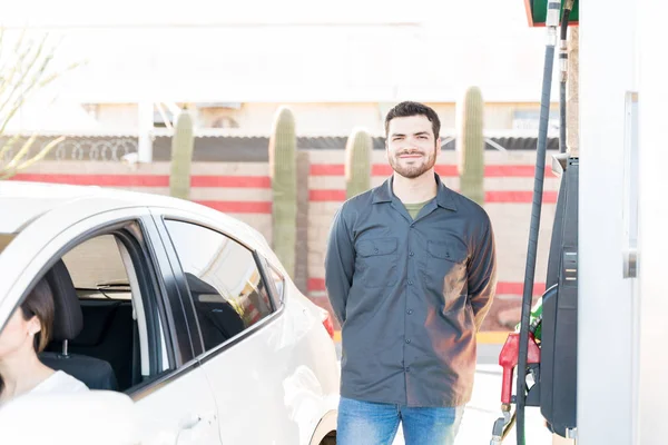 ガソリンスタンドの燃料ポンプのそばに立つ確信のある男性乗務員 — ストック写真