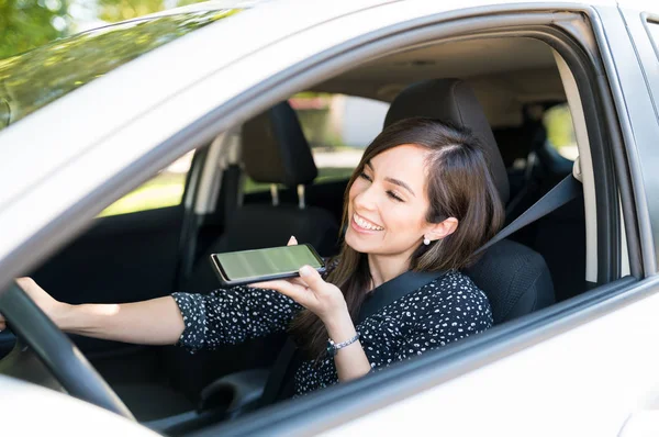 笑顔の中大人の女性が車の中で座っている間にスマートフォンで話して — ストック写真