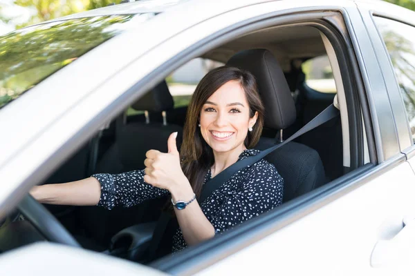 新車を運転しながら親指を立てて笑顔の魅力的な女性の肖像 — ストック写真