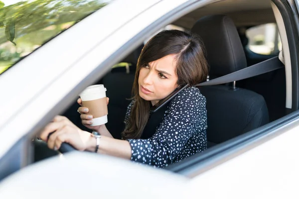 車を運転しながら携帯電話で話す中大人の女性 — ストック写真
