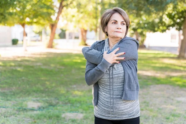 Confident Elderly Caucasian Woman Looking Away While Stretching Her Arms — Stock Photo, Image