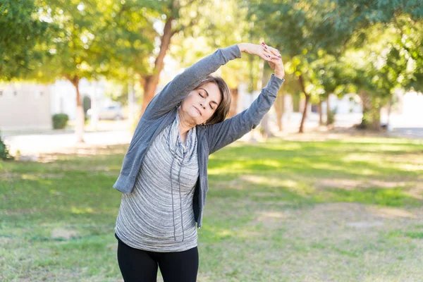 Yaşlı Bir Kadın Parkta Spor Kıyafetlerini Giyerken Kollarını Kaldırarak Egzersiz — Stok fotoğraf