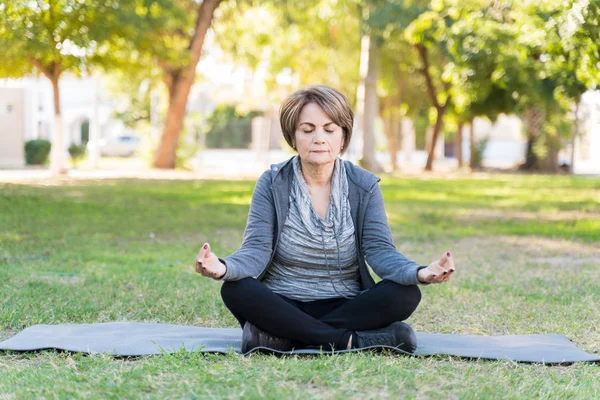 Äldre Kaukasiska Kvinna Mediterar Med Korsben Medan Hon Utövar Yoga — Stockfoto