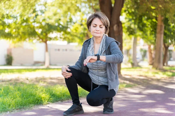 Selbstbewusste Ältere Frau Schaut Auf Smartwatch Während Sie Auf Bürgersteig — Stockfoto