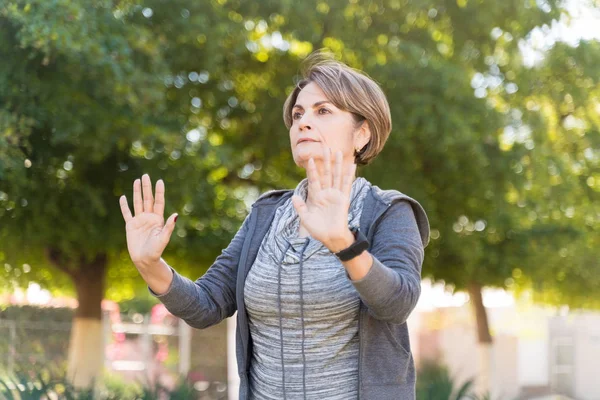 公園で飼育された腕で立ちながら太極拳を練習するシニア女性にフィット — ストック写真