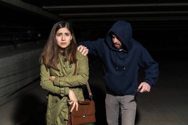 Bıçaklı erkek hırsız gecenin karanlığında korkmuş kadın kurbana arkadan saldırıyor.