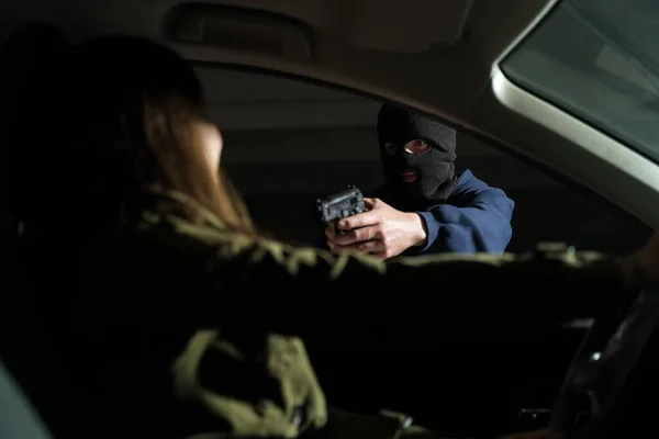 Strafrechtelijk Wapen Gericht Jonge Vrouw Zittend Haar Auto — Stockfoto