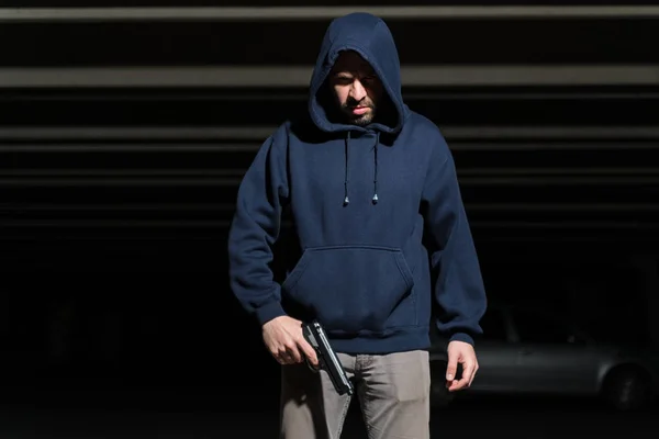 暗い駐車場に立っている間に銃を保持ヒスパニック男性泥棒 — ストック写真