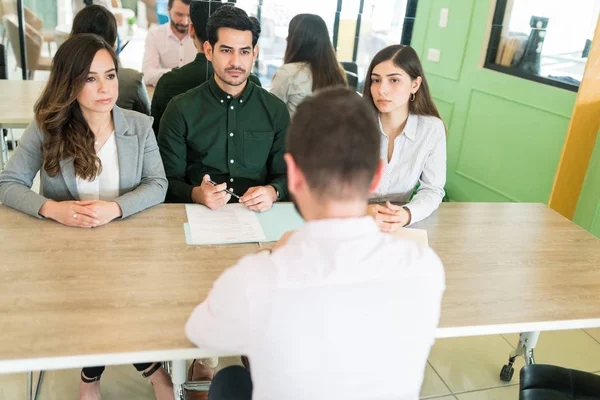 HR representatives listening to male candidate during job interview at office