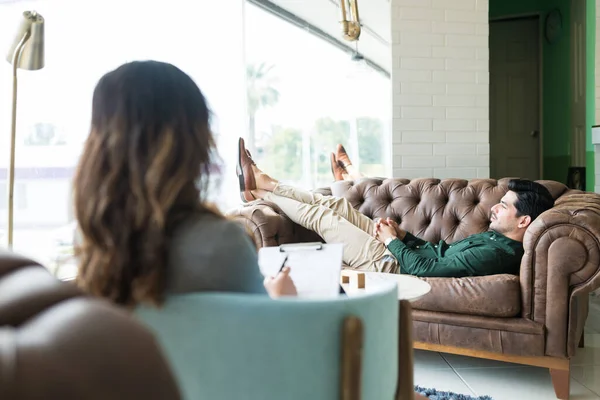 うつ病ヒスパニック系の男はソファに横たわっながら オフィスでのセッション中にセラピストとの問題を議論 — ストック写真