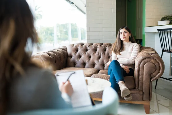 オフィスでの治療セッション中に心理学者からのアドバイスを求めて落ち込んでいる女性 — ストック写真