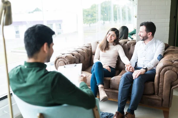 Reconciled Happy Couple Holding Hands While Talking Young Therapist Office — Stock Photo, Image