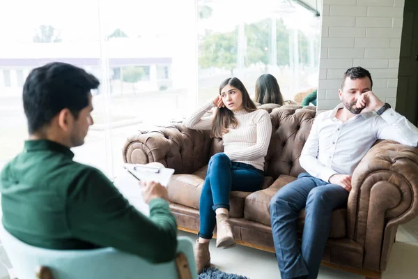 Disappointed couple seeking advise from male psychologist in office