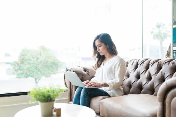 Mladá Žena Pomocí Notebooku Zatímco Sedí Gauči Kanceláři — Stock fotografie
