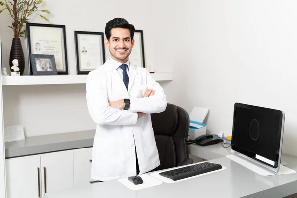 Confident Latin Male Doctor Standing Arms Crossed Desk Clinic — Stock Photo, Image
