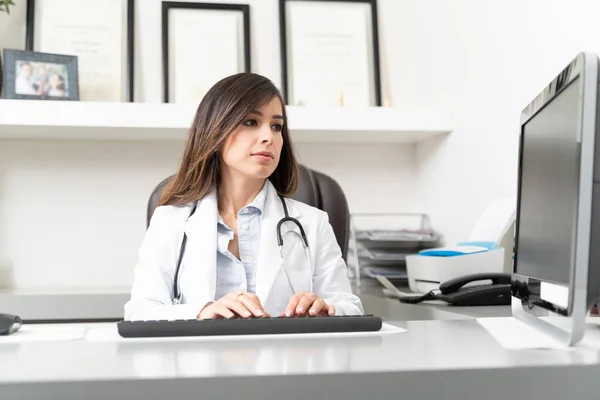 Médica Usando Computador Enquanto Sentada Mesa Clínica — Fotografia de Stock