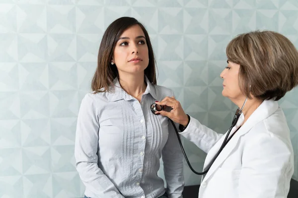 의사는 진료소에서 여성의 청진기 검사를 환자를 검사한다 — 스톡 사진