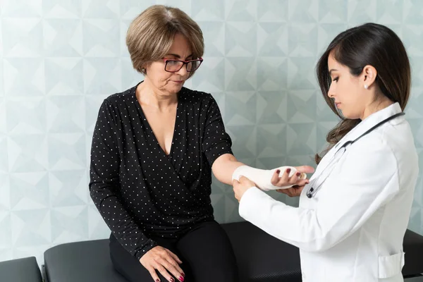 Confident Female Doctor Putting Bandage Elderly Woman Hand — Stock Photo, Image