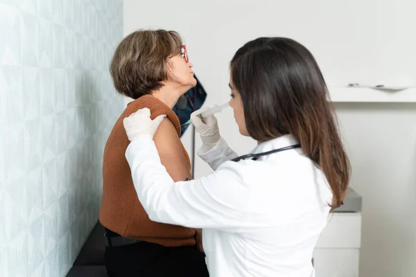 診療中の高齢患者の腕に注射器を注射する婦人科医 — ストック写真