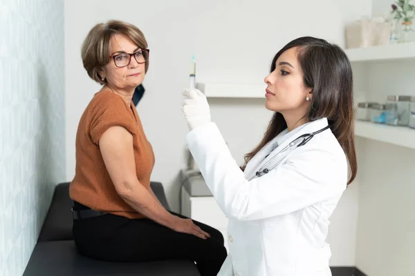 Geriatra Feminina Confiante Preparando Seringa Para Injetar Mulher Idosa Sentada — Fotografia de Stock