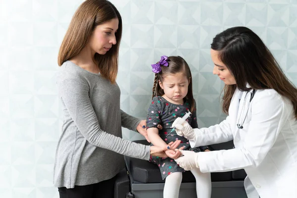 Kadın Doktor Klinikte Gözleri Kapalı Oturan Korkmuş Küçük Kızın Elinden — Stok fotoğraf
