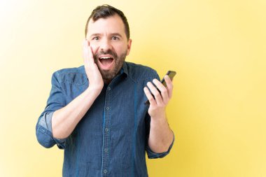 Sarı arka planda akıllı telefonu tutan İspanyol 'a şaşırdım.