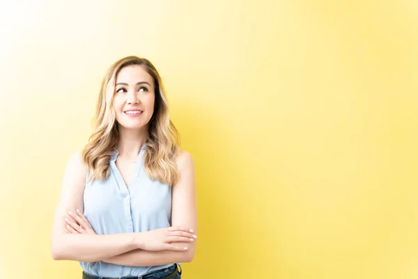 Glimlachende Mooie Vrouw Zoek Naar Boven Terwijl Overweegt Tegen Gele — Stockfoto