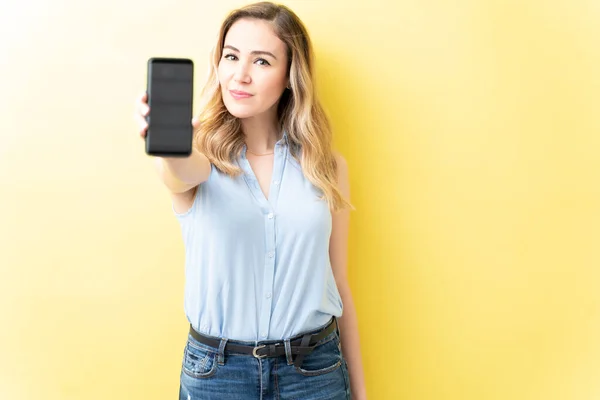 Zelfverzekerde Volwassen Vrouw Toont Mobiele Telefoon Tegen Gele Achtergrond — Stockfoto