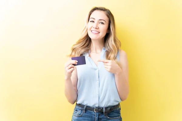 Usmívající Krásná Žena Ukazuje Kreditní Kartu Zatímco Stojí Žlutém Pozadí — Stock fotografie