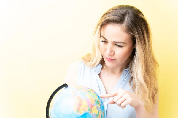 Mooie Volwassen Vrouw Wijzend Globe Tegen Gele Achtergrond — Stockfoto