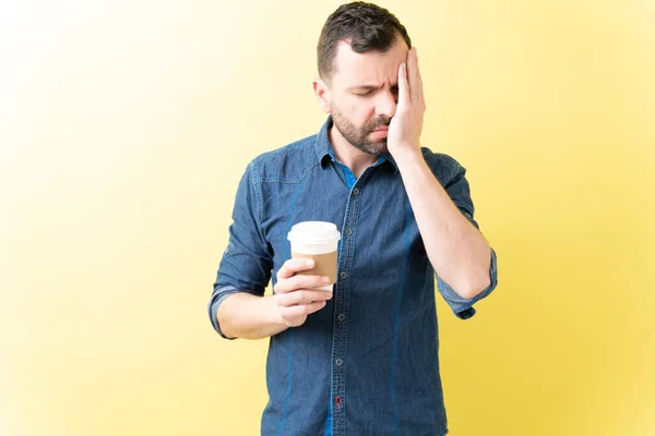 Lateinischer Mann Mit Kopfschmerzen Hält Einweg Kaffeetasse Vor Gelbem Hintergrund — Stockfoto