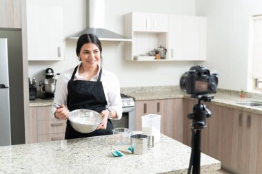 Kendine güveni tam fırıncı un karıştırırken mutfak kamerasından video bloğu yapıyor.