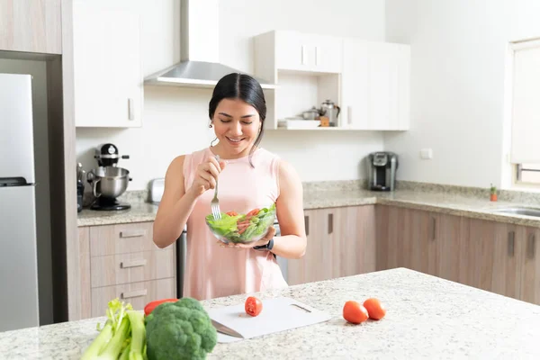 漂亮活泼的年轻女子在家里厨房里吃新鲜健康的蔬菜沙拉 — 图库照片