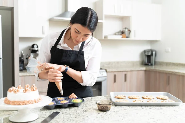 Confiante Jovem Chef Pastelaria Decorando Cupcakes Panela Balcão Cozinha Casa — Fotografia de Stock