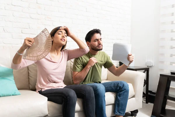 Hispanic Couple Waving Hand Fan Papers While Feeling Hot Home — Stock Photo, Image