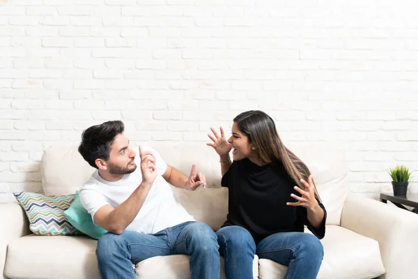 Irriterad Ung Kvinna Skriker Pojkvän Sittande Soffan Vardagsrummet — Stockfoto